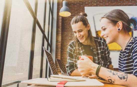 Two social media managers looking at their laptops