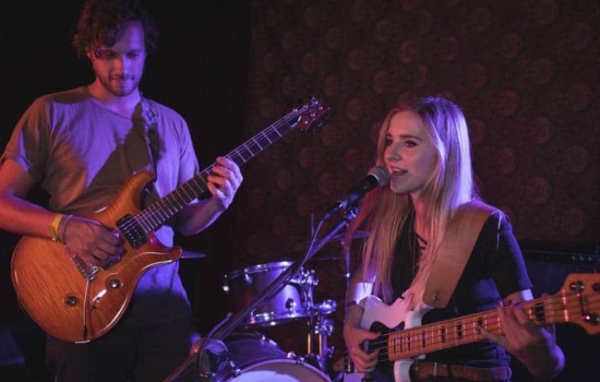 Male and female band members sound checking onstage