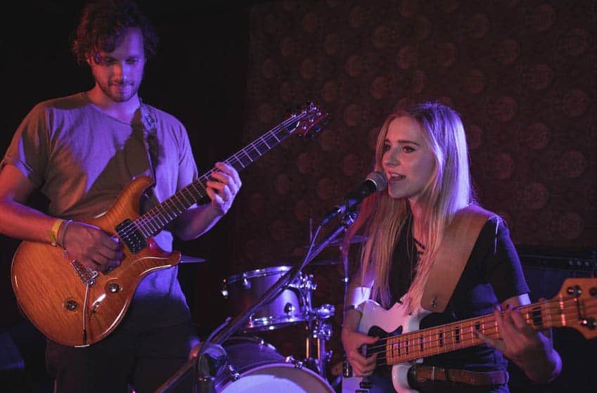 Male and female band members sound checking onstage