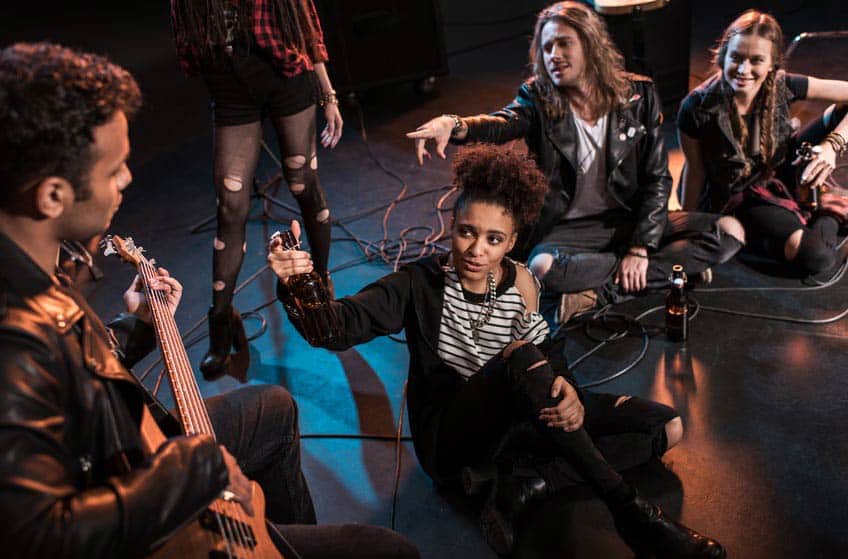 Bandmates hanging out on an empty venue stage