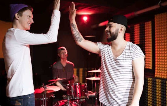 A&R Rep high fiving bandmates in rehearsal space