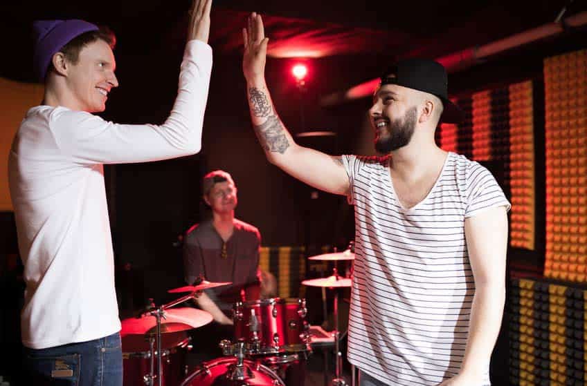 A&R Rep high fiving bandmates in rehearsal space