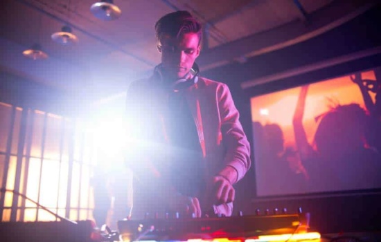 Male DJ twisting knobs on his mixer at party