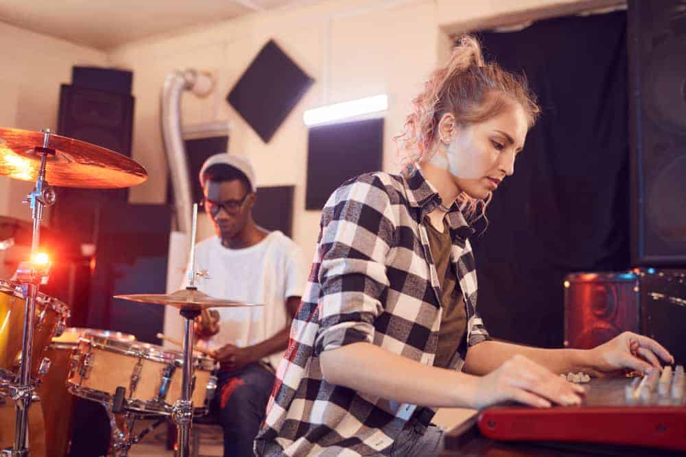 Drummer and keyboard player in rehearsal space