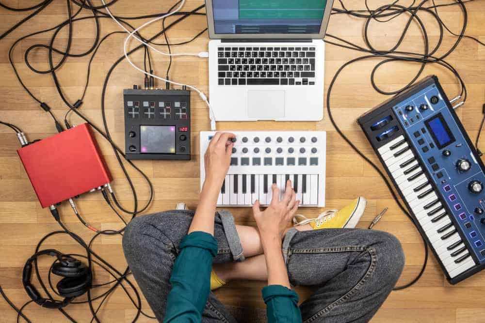 person making music on the floor surrounded by instruments