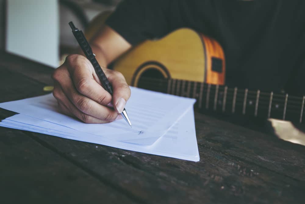 Writing lyrics with sheet music and guitar