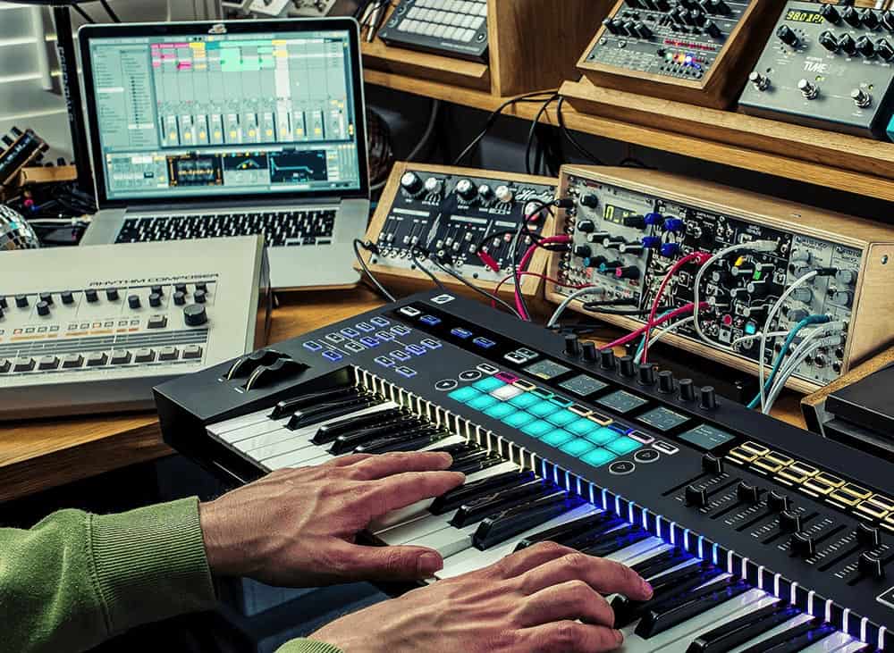 Hands playing Novation keyboard with daw and eurorack