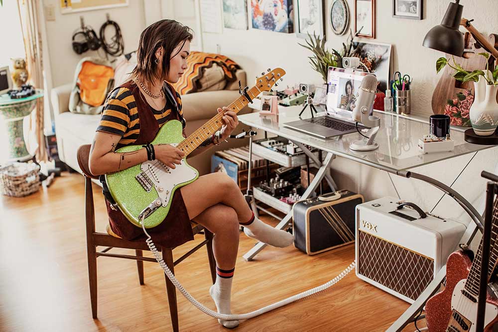 Female musician livestreaming a performance using a USB microphone