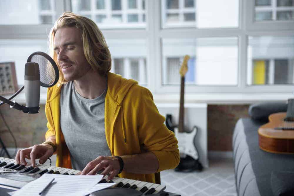 Man singing and playing keyboards in his apartment