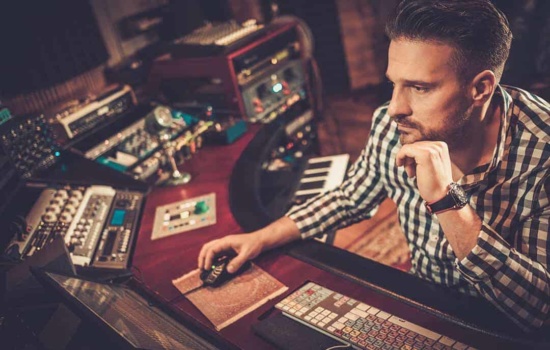 Male sound engineer mixing music in the recording studio