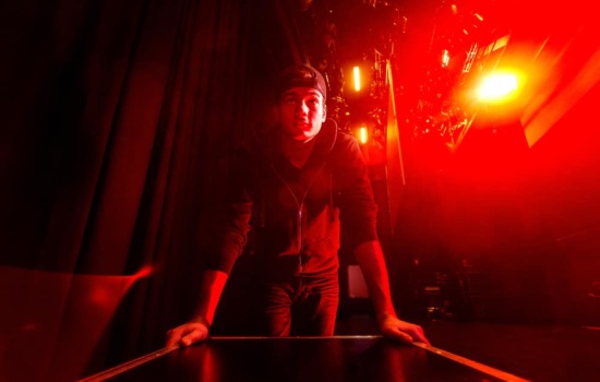 Stagehand transporting musical gear backstage