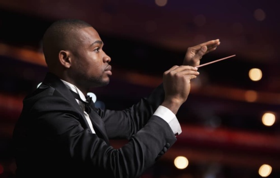 Black male conductor in a theatre space