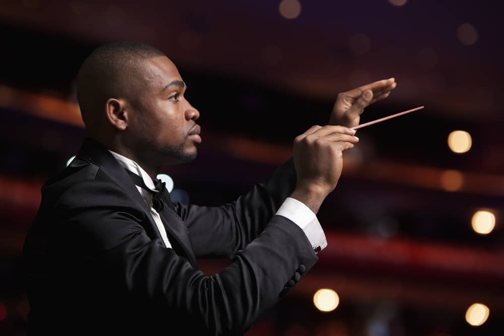 Black male conductor in a theatre space