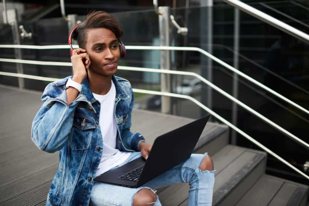 Young male musician using beat making software on his laptop