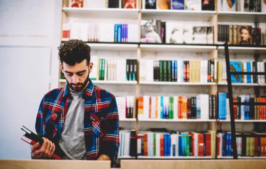 Young man looking for music books at a book store