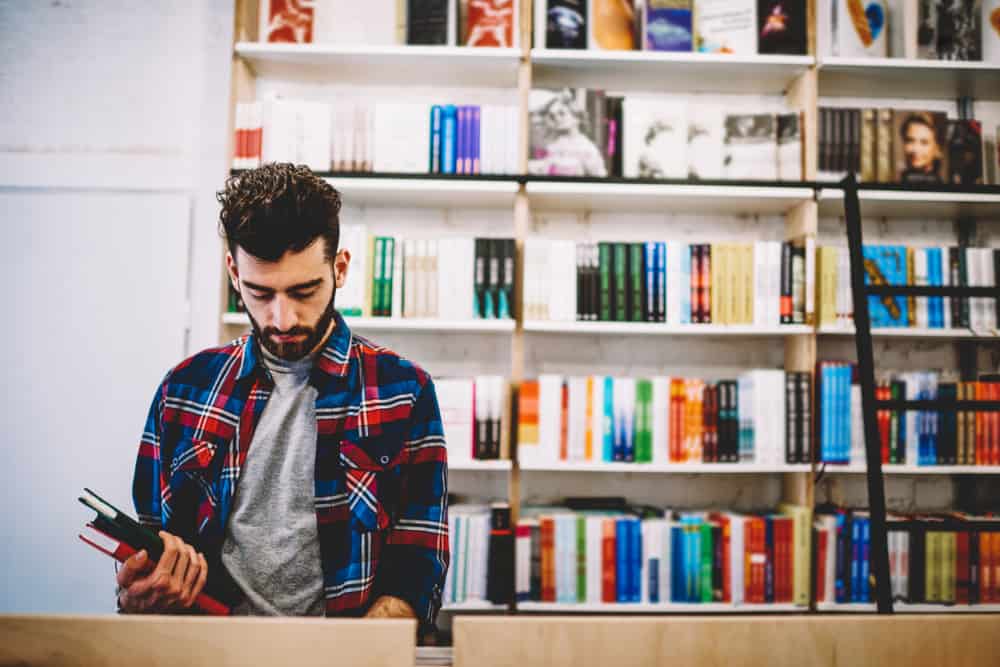 Young man looking for music books at a book store