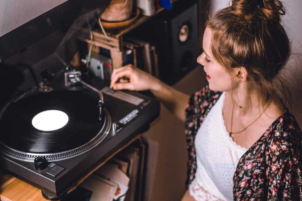 Young woman listening to music on record player