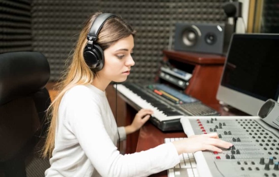 Female audio engineer making music in recording studio