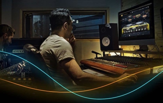 Audio Engineer behind control desk in recording studio