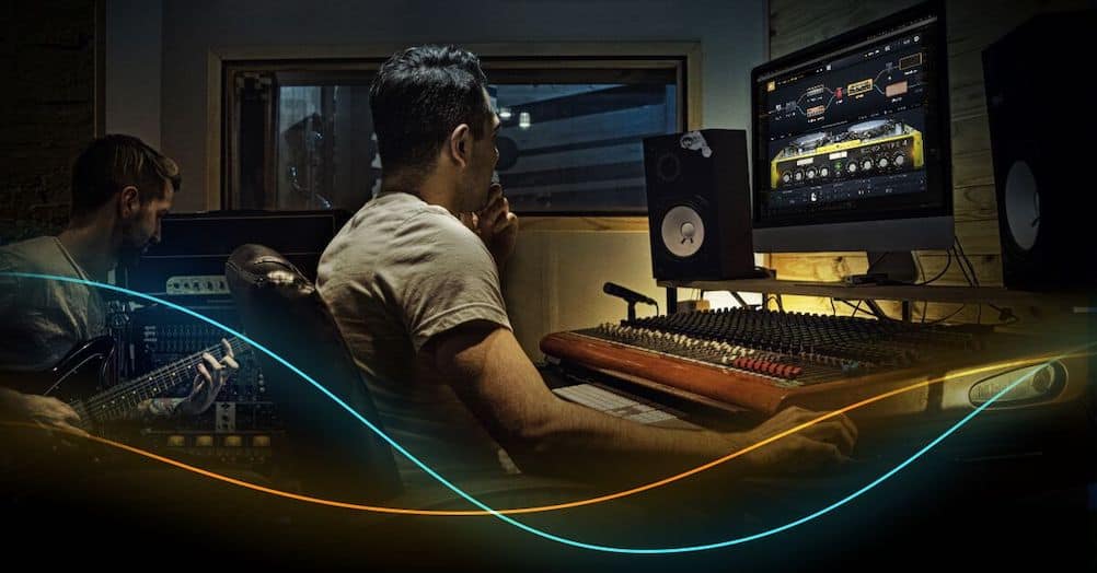 Audio Engineer behind control desk in recording studio