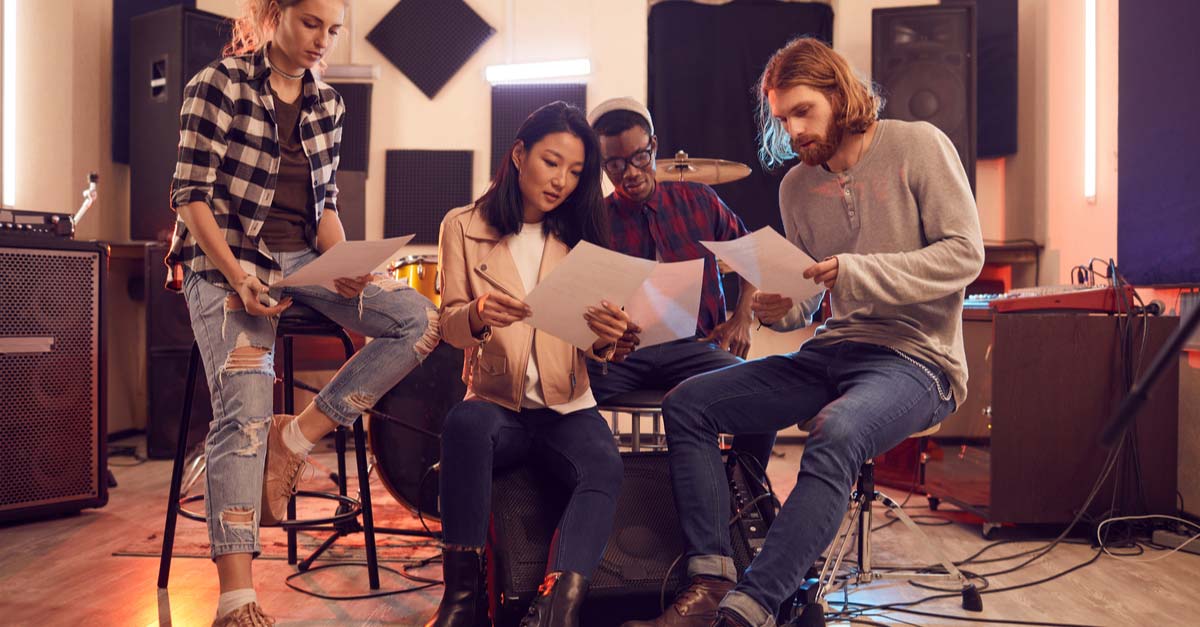 Band members in practice space reading sheet music