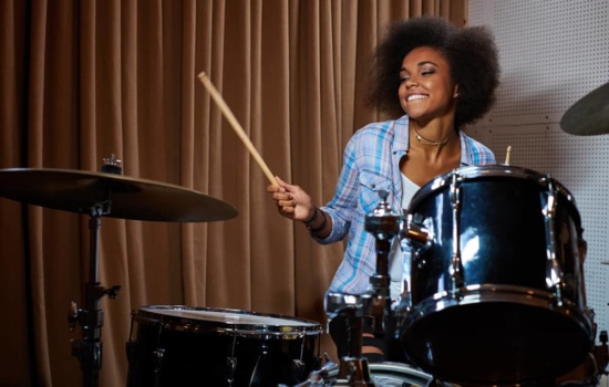 Young female drummer in practice space