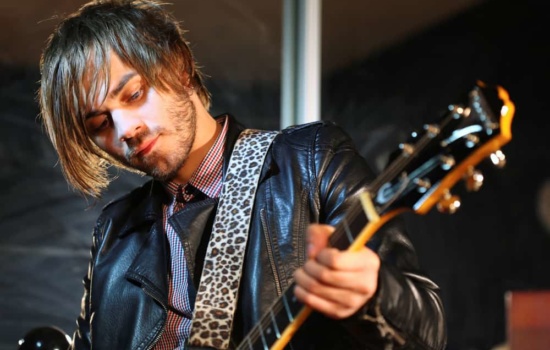 Musician in leather jacket playing guitar