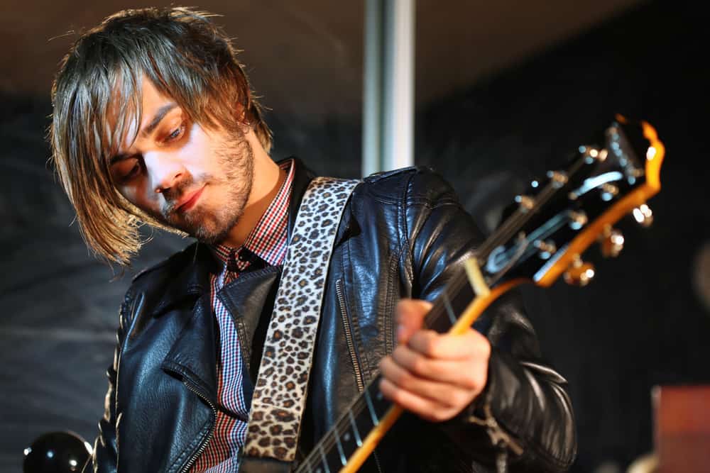 Musician in leather jacket playing guitar
