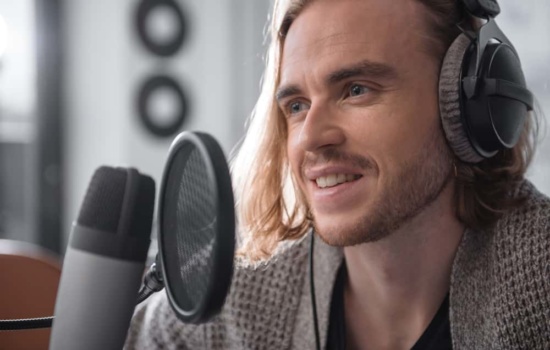 Cheap microphone and pop filter with male singer wearing headphones