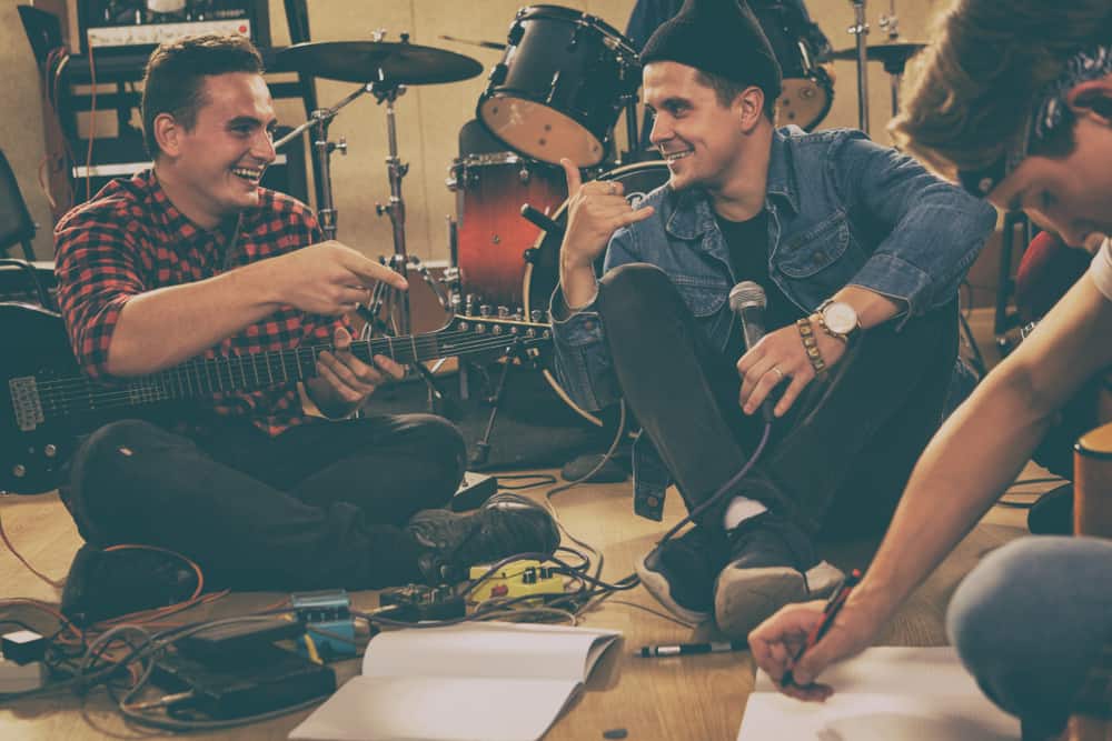 Bandmates writing a bridge in a song at their practice space