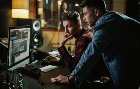 Two music producers using DAW in professional recording studio