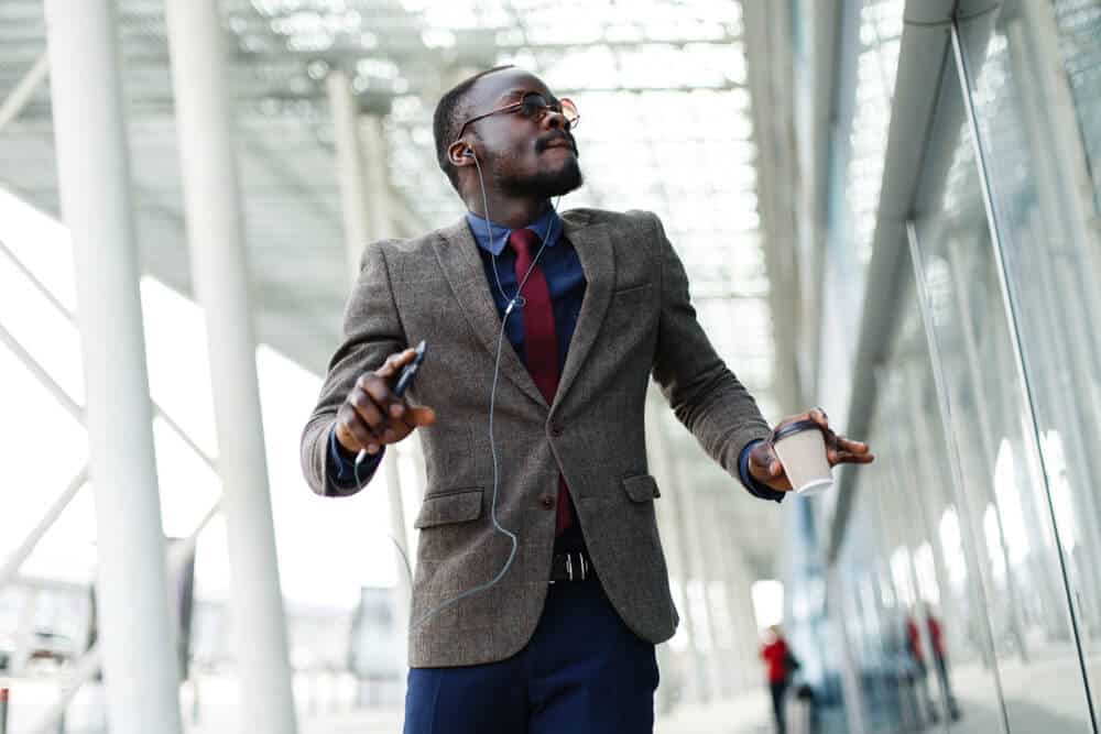 Music businessman dancing through the hall of an office building