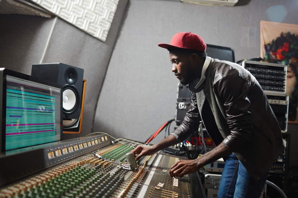 Music producer behind mixing console in recording studio