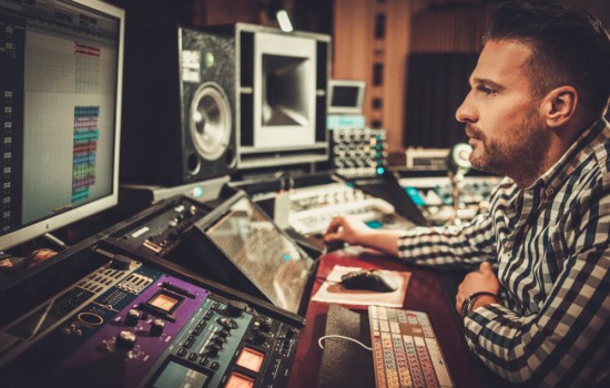 Record producer recording an album in his studio