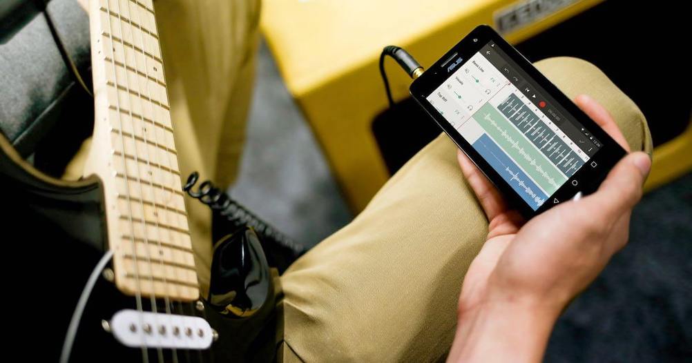 Musician using Android music-making app to record guitar