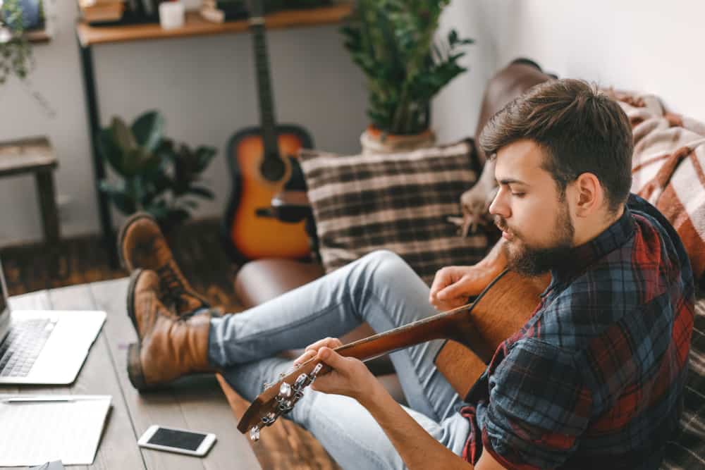 Man playing guitar in his living room