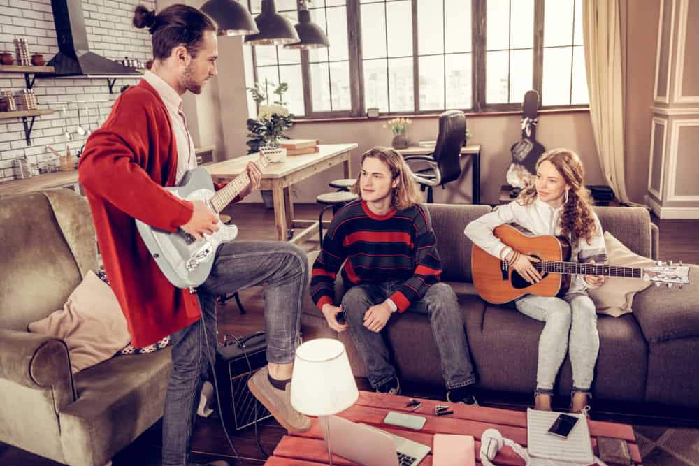Guitar player showing fellow musicians how to play a song