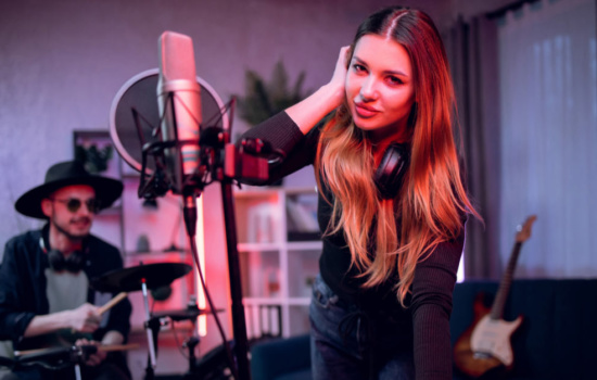 Male and female band members working on a music marketing plan in their home studio