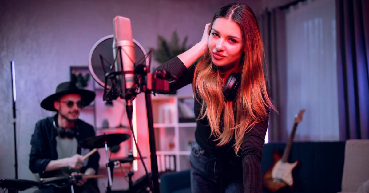 Male and female band members working on a music marketing plan in their home studio