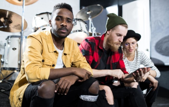 Artist Relations Development Rep hanging out with the musicians he represents in their rehearsal space