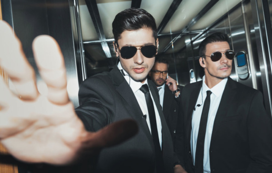 Celebrity Bodyguards with client in elevator