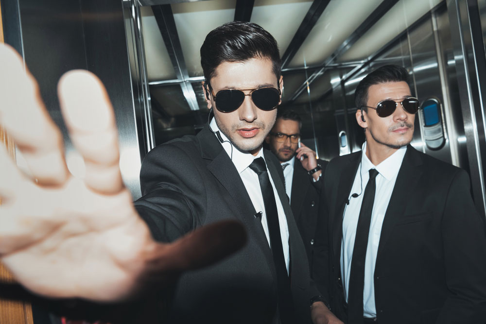 Celebrity Bodyguards with client in elevator