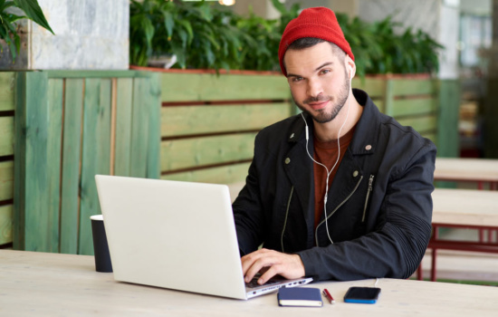 Music Marketing Representative works on his laptop on the patio of his office space