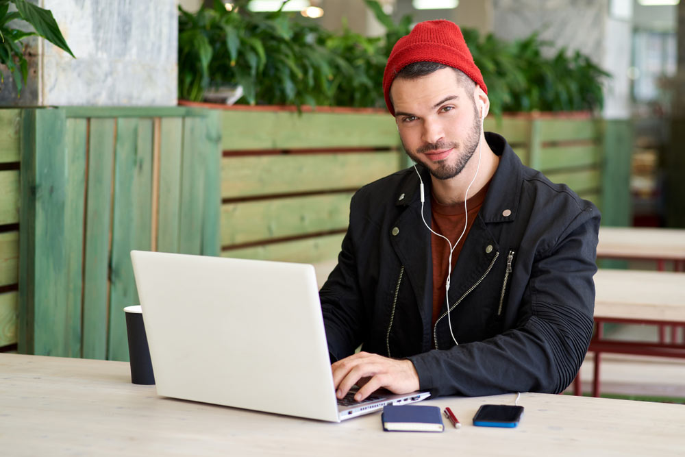 Music Marketing Representative works on his laptop on the patio of his office space