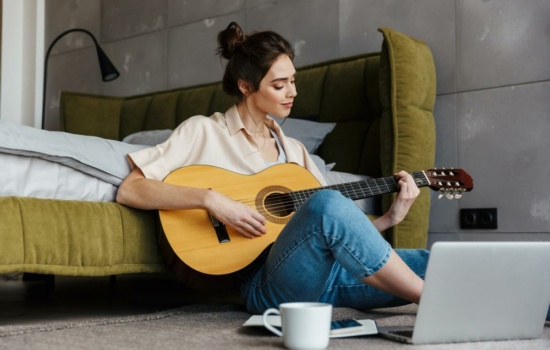 Female guitarist learning how to make a song