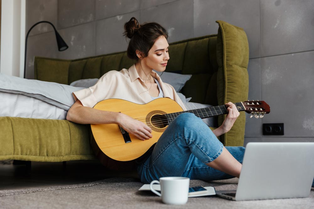 Female guitarist learning how to make a song