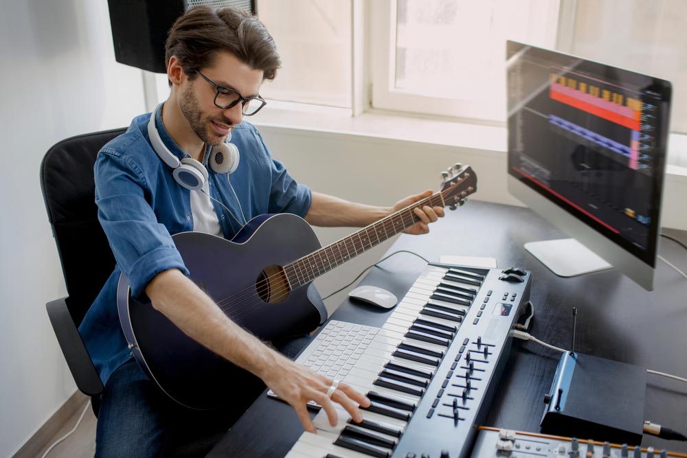 Male musician in home studio using some of the best free music production software