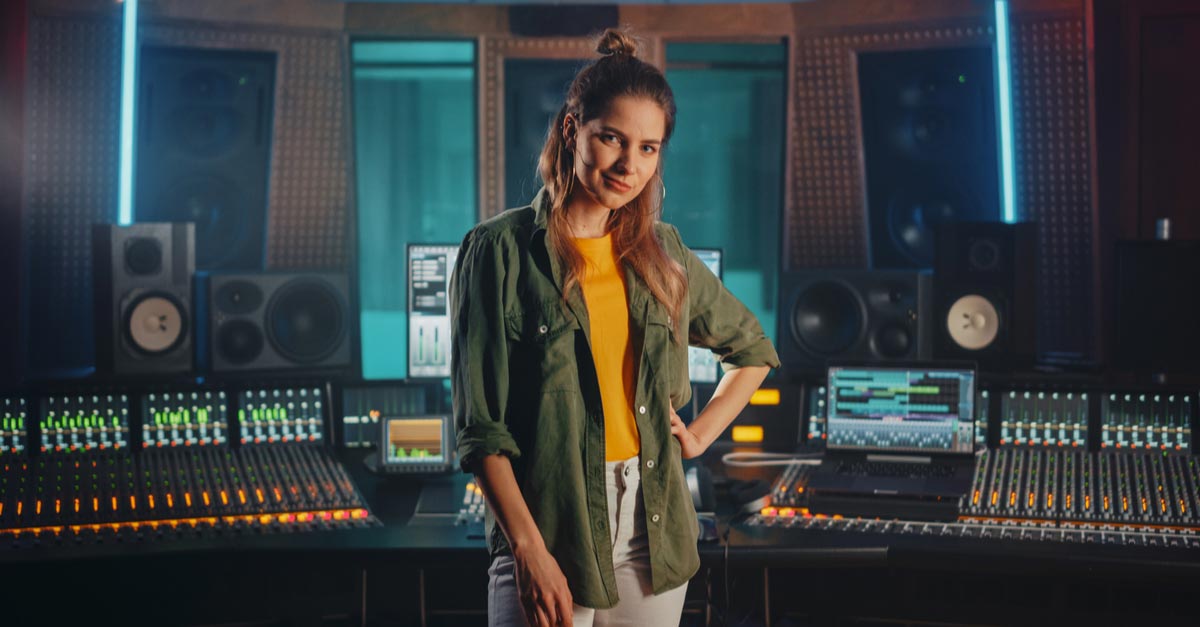 Young female Audio Engineer with soundboard in recording studio