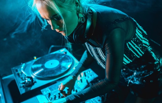 Female DJ using mixer during live DJ set