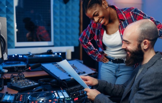 Male and female Recording Engineers in studio
